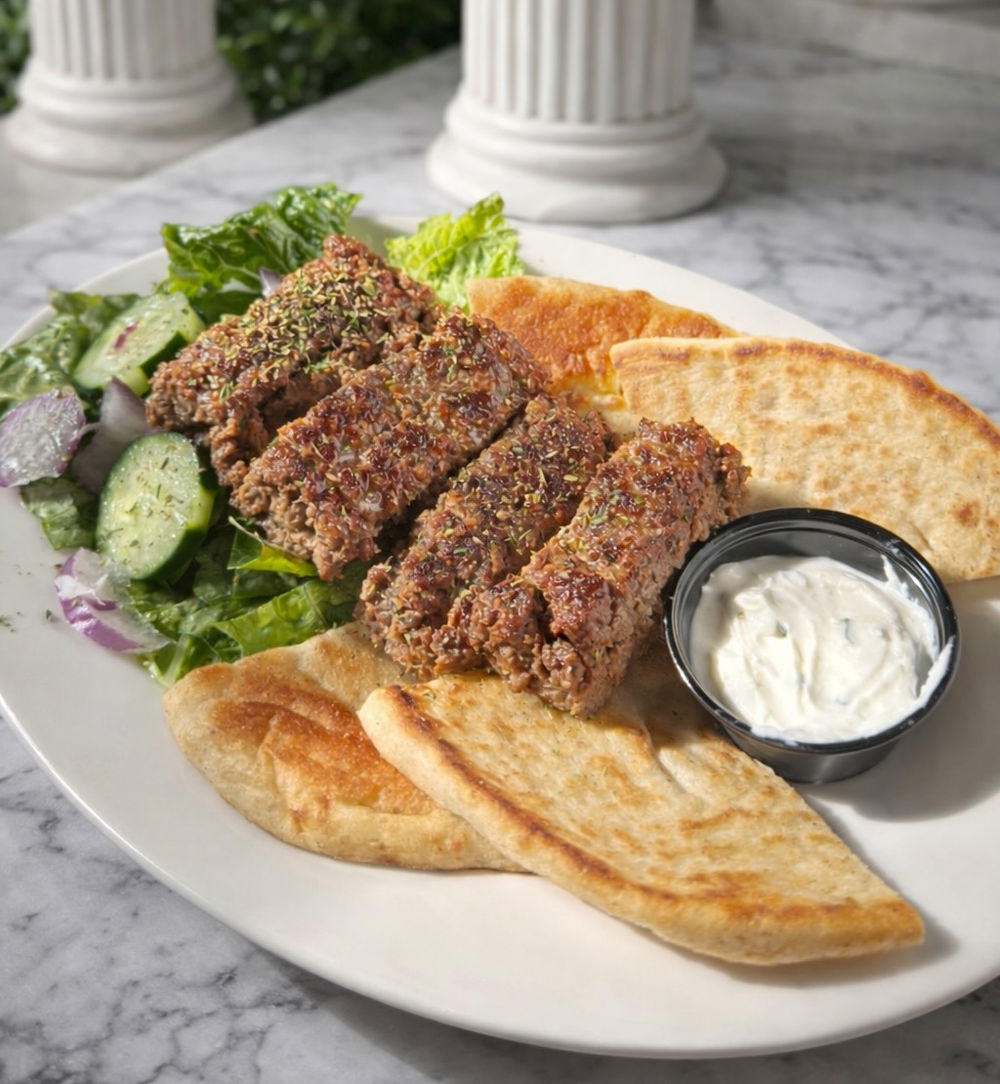Kofta over salad with pita and tzatziki